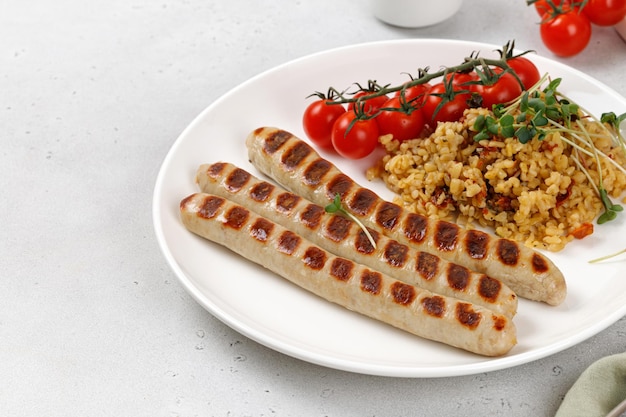 Prato com salsichas de frango de churrasco bulgur tomate cereja e microgreen Keto dieta saudável