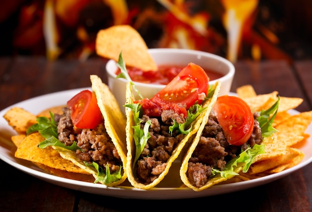 Prato com taco, nachos chips e molho de tomate