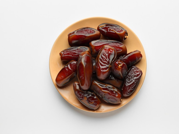 Prato com tâmaras secas para o Ramadã em fundo branco