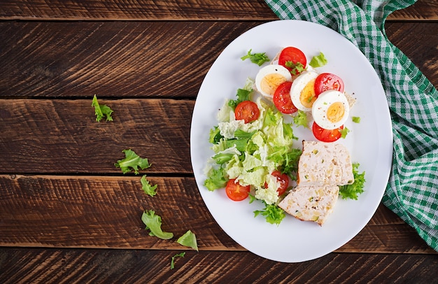 Prato com um alimento dietético cetônico. sanduíche com ovo cozido e tomate. bolo de carne e salada. keto, café da manhã paleo. vista superior, configuração plana