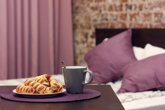 Prato com uma sobremesa doce e uma caneca sobre a mesa em um fundo desfocado