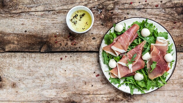 Prato de antepasto com presunto, presunto, queijo mussarela e rúcula