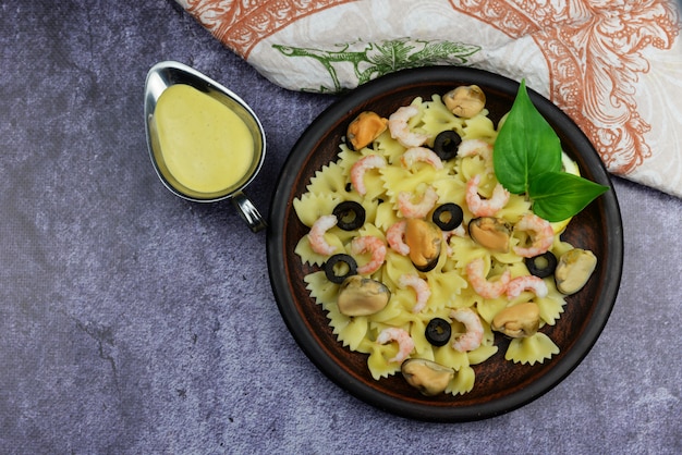 prato de arco de macarrão italiano com camarão de frutos do mar e mexilhões em um plat