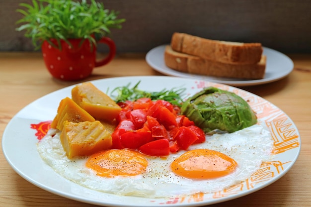 Prato de café da manhã saudável com ovos estrelados com salada de legumes colorida