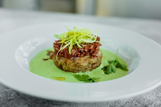 Prato de carne com arroz, fatias de cebola, verduras e molho