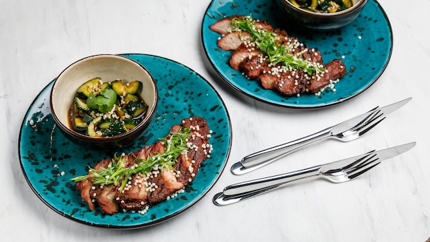 Prato de carne de cozinha japonesa com legumes em uma mesa branca