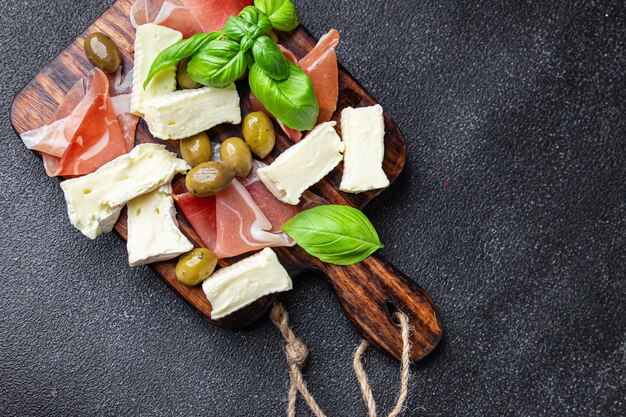 Prato de carne ou prato de queijo jamon, queijo, azeitonas refeição saudável lanche em cima da mesa