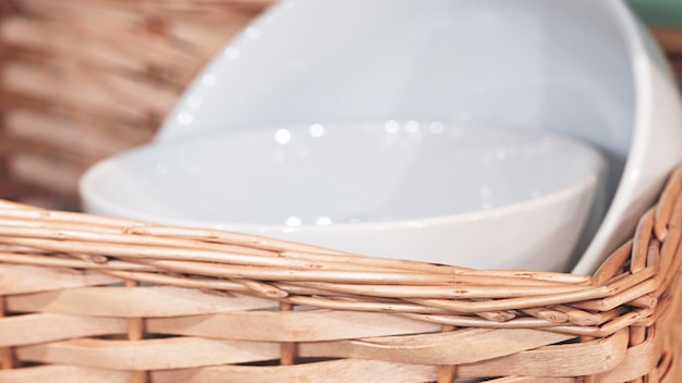 Prato de cerâmica branca limpa em uma cesta conceito de estilo rústico