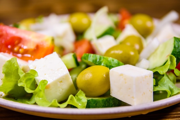 Prato de cerâmica com salada grega na mesa de madeira rústica