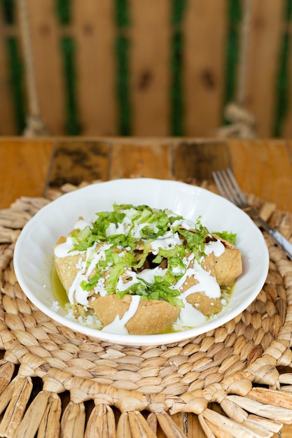 Prato De Chilaquiles Servido Em Um Prato Branco Preparado Com Salgadinhos De Milho Creme De Alface E Queijo