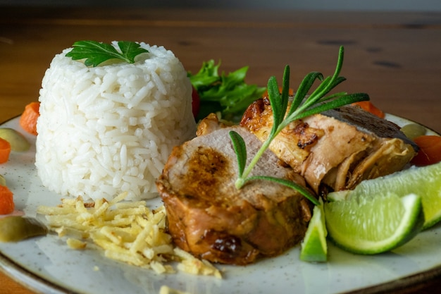 prato de comida arroz, carne, salada e batatas em um prato refeição completa