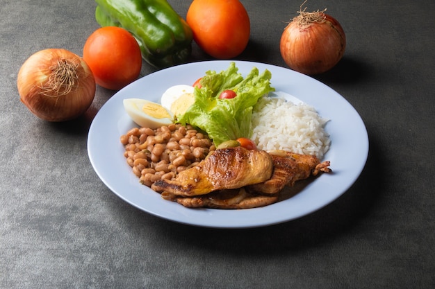 Prato de comida brasileira com arroz de feijão e frango.