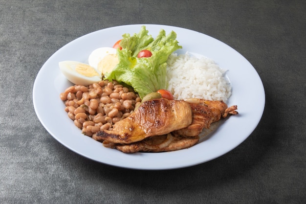 Prato de comida brasileira com arroz de feijão e frango.