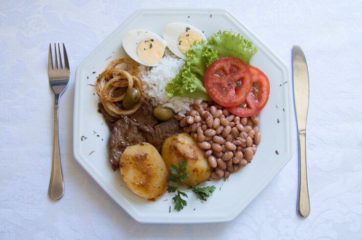 Prato de comida brasileira na mesa branca, vista superior.