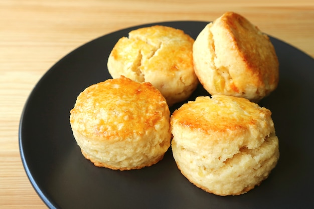 Prato de Deliciosos Scones Caseiros de Raspas de Laranja Cristalizadas na Mesa de Madeira