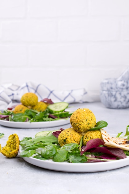 Prato de falafel com pão pita, molho e salada de folhas