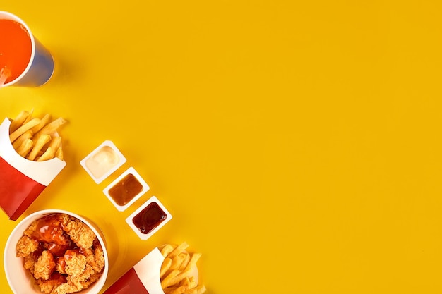 Foto prato de fast food em fundo amarelo conjunto de fast food frango frito e batatas fritas leve embora fast food