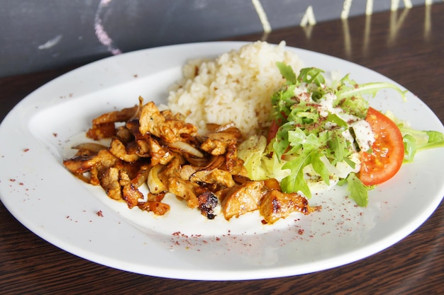 Prato de frango salteado com legumes e arroz.