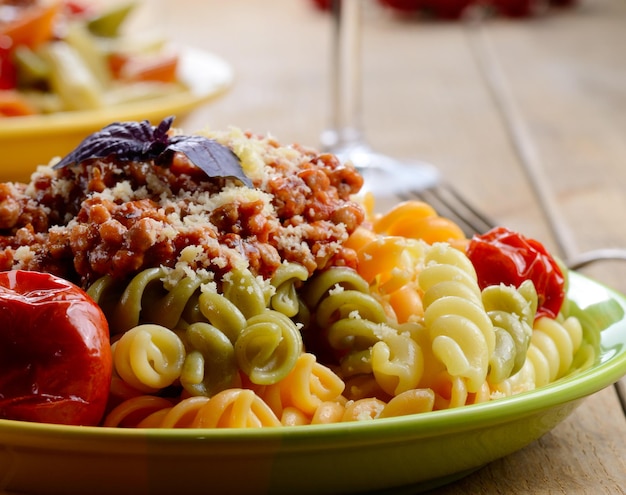 Prato de macarrão com molho de tomate à bolonhesa na mesa da cozinha