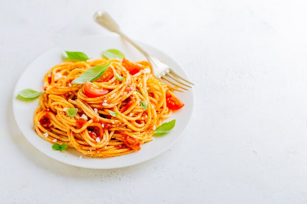 Prato de macarrão com molho de tomate no prato branco