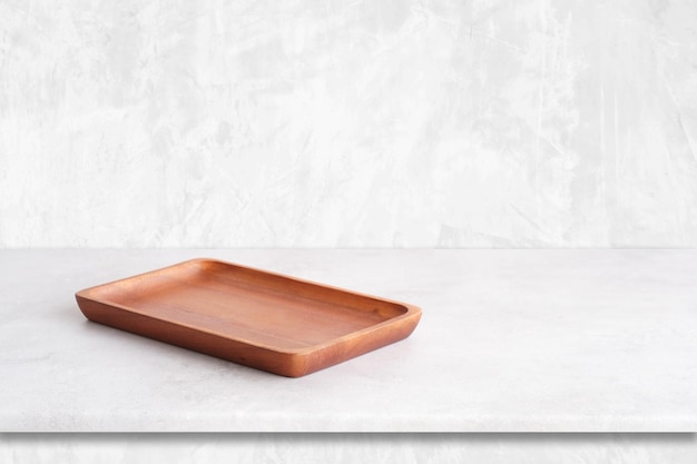Prato de madeira redondo vazio na mesa de cimento branco e fundo de parede