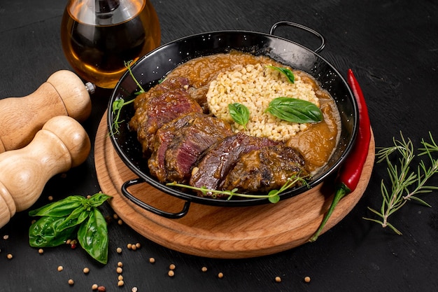 Prato de molho de carne grelhada e arroz em fundo de madeira