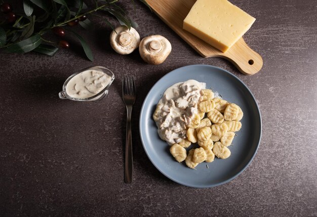 Prato de nhoque italiano tradicional cozido com molho cremoso de cogumelos e queijo