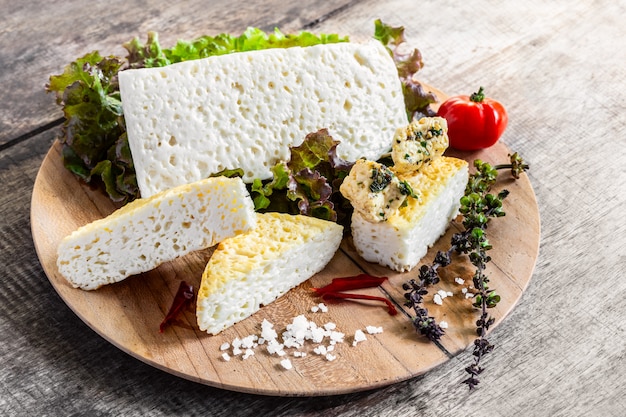 Prato de queijo feta com verduras e especiarias na mesa de madeira rústica