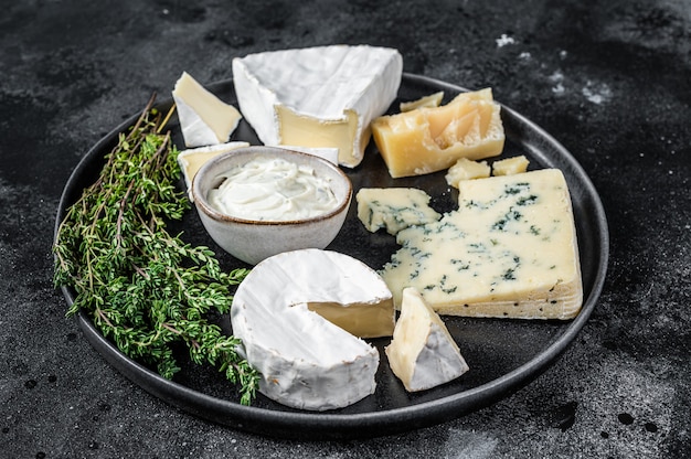 Prato de queijo francês. Camembert, Brie, Gorgonzola e queijo cremoso azul. Fundo preto. Vista do topo.