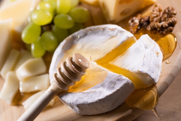 Prato de queijo, mel derramando no queijo camembert