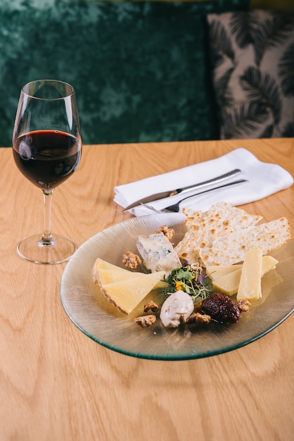 Prato de queijo na mesa com uvas e nozes petiscos para vinho