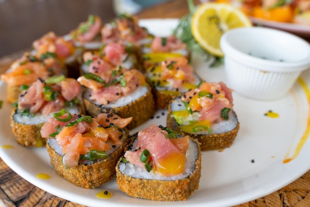 Prato de rolo de sushi crocante com salmão e ciboulette por cima. restaurante japonês com estilo mexicano