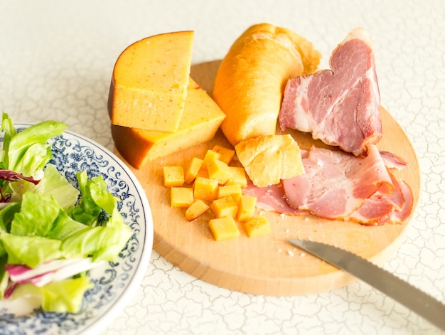 Prato de salada de folhas verdes, presunto e queijo