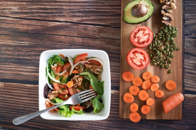 Prato de salada de legumes em fundo de madeira vintage. Comida vegetariana saudável, vista superior.