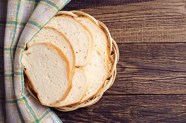 Prato de vime com fatias de pão branco na mesa