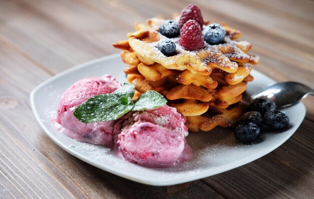 Prato de waffles belgas com sorvete e frutas frescas framboesas e mirtilos