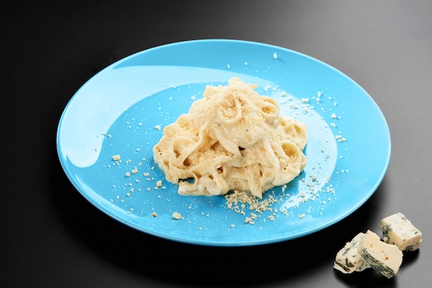 Prato italiano Penne macarrão coberto formaggio cremoso saboroso molho e manjericão servido prato azul