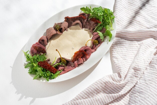 Prato italiano Vitello tonnato Vitela em fatias finas com molho de atum alcaparras e coentros