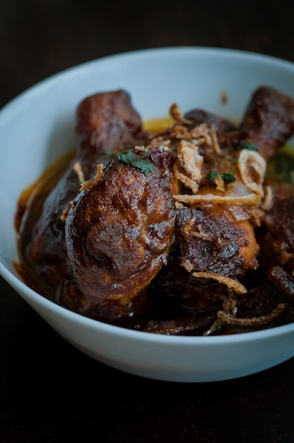 Foto prato malaio de ayam masak kicap ou frango frito em molho de soja preto em uma tigela branca