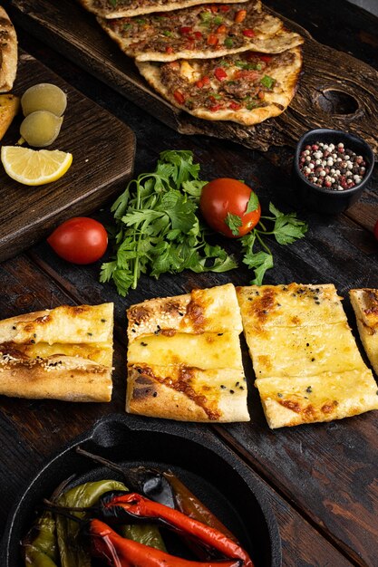 Foto prato pide turco com tomate e queijo salgado no fundo da velha mesa de madeira escura