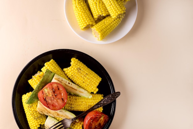 Foto prato preto de abobrinha de legumes grelhado milhotomate dieta saborosa e saudável comida fundo amarelo