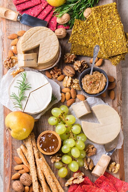 Prato servido com variedade de não lácteos orgânicos, queijo cru de castanha de caju com salgadinhos, frutas. Vegan, vegetariano, comida à base de plantas, nutrição e dieta, conceito de alimentação saudável.