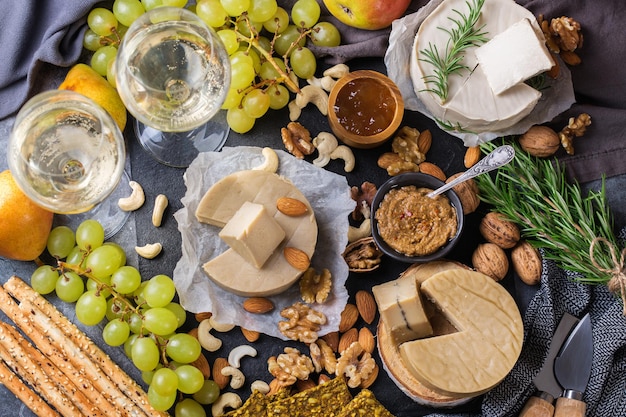 Prato servido com variedade de não lácteos orgânicos, queijo cru de castanha de caju com salgadinhos, frutas. Vegan, vegetariano, comida à base de plantas, nutrição e dieta, conceito de alimentação saudável.