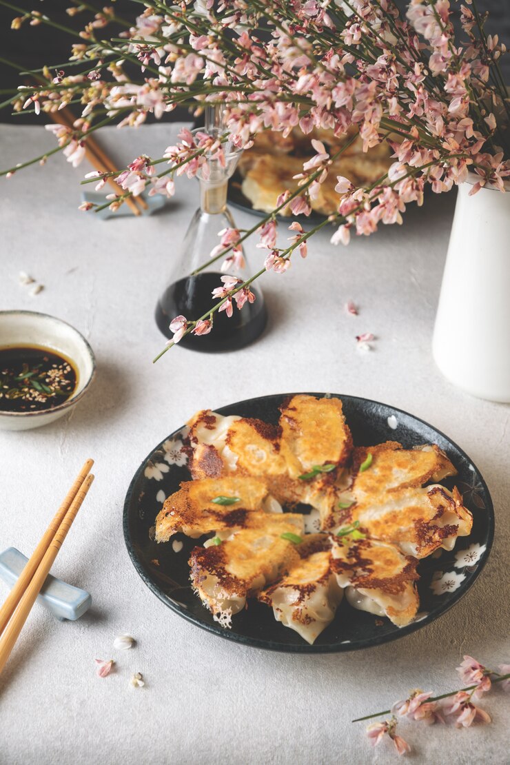 Prato servido de bolinhos fritos de gyoza japonês com molho de soja na mesa de luz
