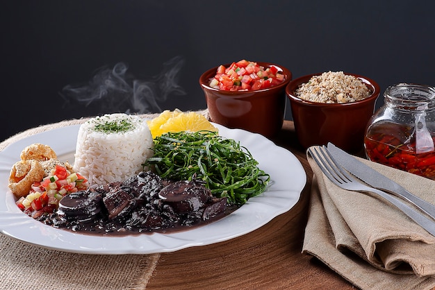 Prato típico da culinária brasileira chamado Feijoada, com feijão preto, bacon, linguiça e porco