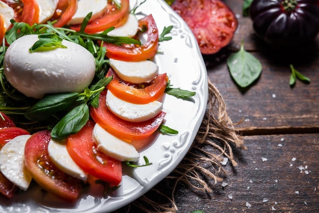 Prato típico italiano de queijo mussarela de vaca ou búfala com azeite de tomate rúcula manjericão