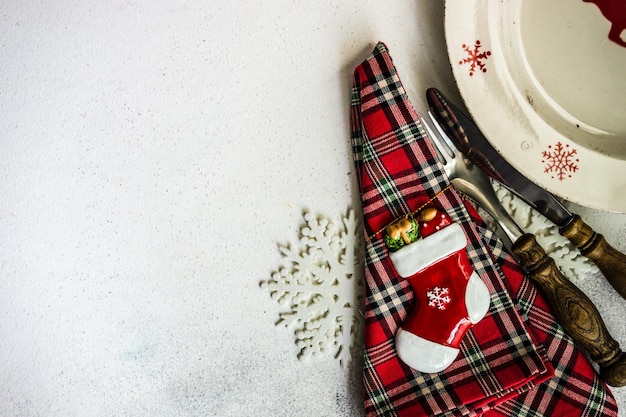 Foto prato vazio com decoração festiva e talheres na mesa para o jantar de natal