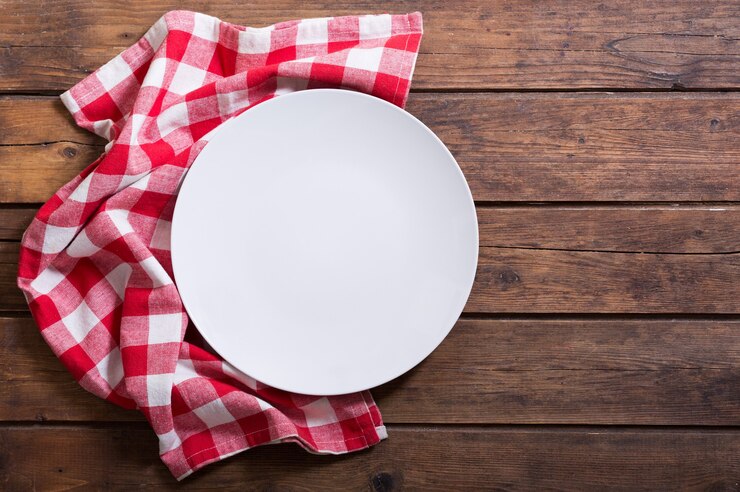 Foto prato vazio com toalha de mesa vermelha na mesa de madeira, vista superior
