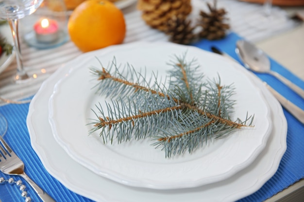 Pratos brancos com talheres em uma mesa de Natal, close-up