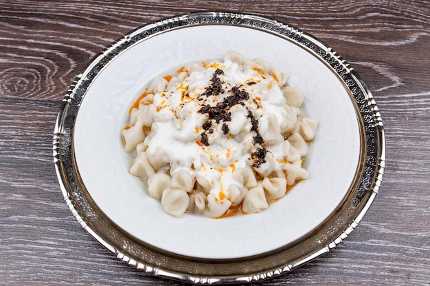 Pratos de comida tradicional turca. Manti com molho de tomate